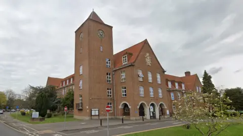 Google A red-bricked building with a clock tower.