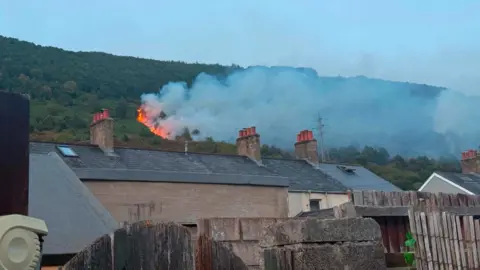 Hayley Atkinson Smoke is seen rising above houses