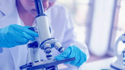 Getty Images Scientist using microscope