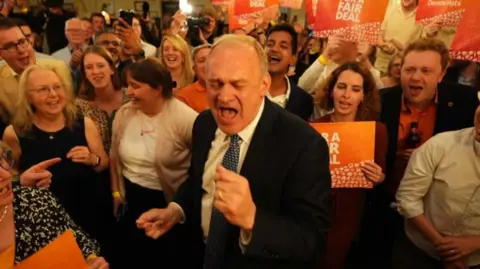 PA Liberal Democrat leader Sir Ed Davey with his mouth wide open and surrounded by his supporters at the London Art Bar in central London watching the results of the 2024 General Election