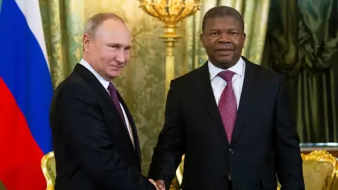 Getty Images Two men in dark suits shaking hands.