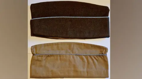 Andy Garner Earl Thurman's garrison caps. One is dark brown with blue piping across the middle. The other is light brown with blue piping across the middle. They are both folded flat and lengthways