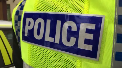 BBC Rear of a police jacket - stock image