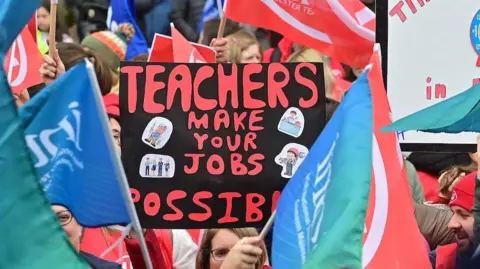 Pacemaker A crowd gathered, one person is holding a sign which says "teachers make your jobs possible"