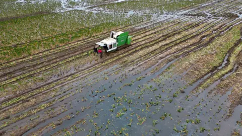 Joe Gidden/PA Wire Farmers in a waterlogged field