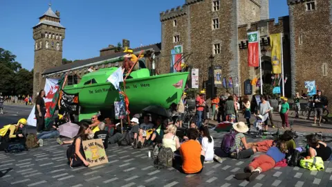 Wales News Service A boat has been placed in the middle of the busy road