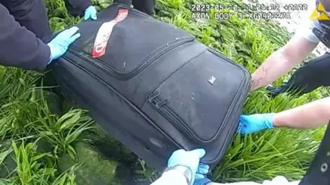 Met police Officers from the Metropolitan Police dragging the suitcase from the river 