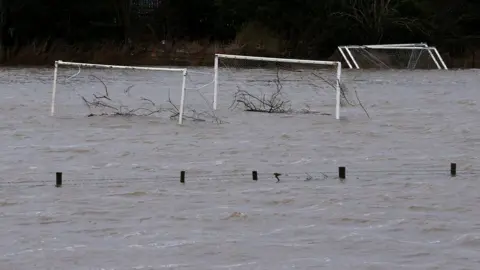 AFP/Getty Images Tree debris was washed away on flooded football pitches in Tadcaster, North Yorkshire