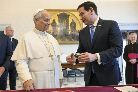 Rubio and the Pope bond over a glass american football model.