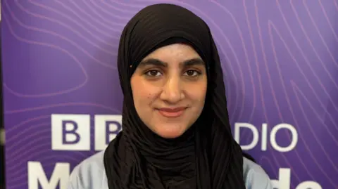 Claire Hamilton/BBC Hadia wears a black hijab and ligth grey cardigan