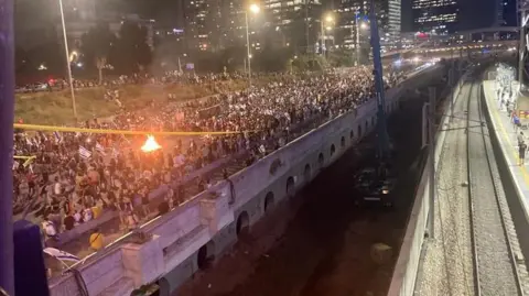 Los manifestantes inician una hoguera en la autopista Ayalon en Tel Aviv.