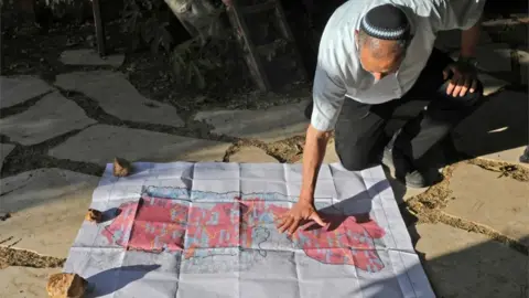 AFP Yochai Damri, head of the Har Hebron Regional Council, shows a map of what Israeli settlers say is a map of a Palestinian state under Donald Trump's peace plan (03/06/20)