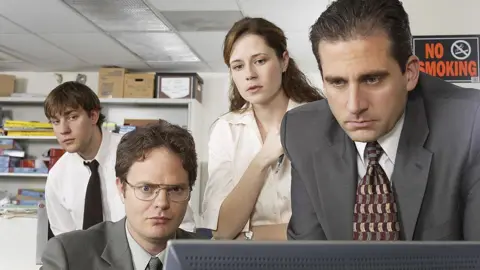 Getty Images (l-r) John Krasinski as Jim Halpert, Rainn Wilson as Dwight Schrute, Jenna Fischer as Pam Beesly, and Steve Carell as Michael Scott in 2004 during the pilot of The Office