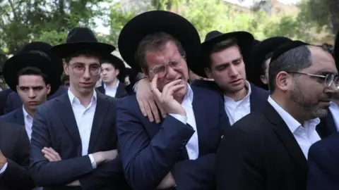 EPA A man weeps at the funeral in Jerusalem of Avrohom Daniel Ambon, one of the 45 people killed in a crush at Lag B'Omer festival in northern Israel (3 May 2021)