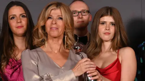 Getty Images Kate Garraway brought her daughter Darcey up to help accept her award