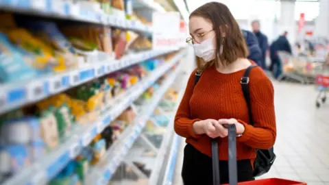 Getty Images A woman wearing a facemask in a supermarket
