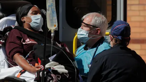 Reuters Medics tend to a woman being admitted to hospital on a trolley in New York