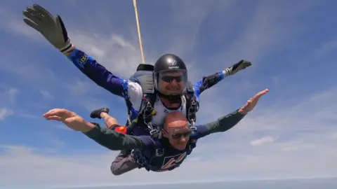 Blind Veterans UK Mark Pile during jump smiling