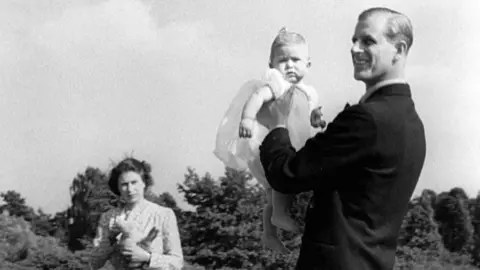 PA Prince Charles, later The Prince of Wales, is lifted up by his father The Duke of Edinburgh, in the grounds of Windlesham Moor, the country home in Surrey of Princess Elizabeth and the Duke. 18 July 1949