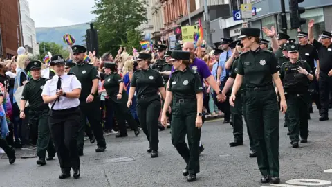 Pacemaker Uniformed police officers waved to the crowds as they marched through Belfast city centre