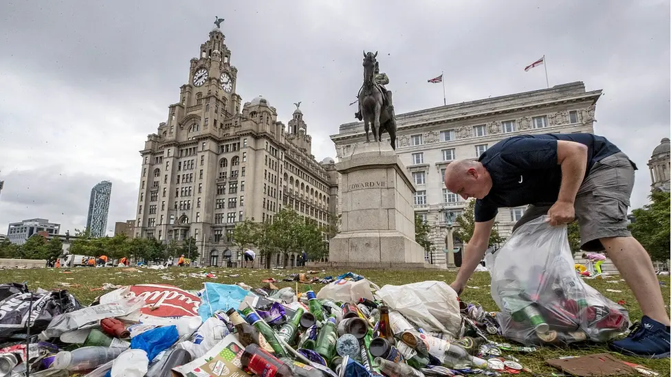 PA Media Man clears up rubbish outside Liver buildings