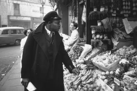 Getty Images Rue Gordon, a bus conductor, seen in Birmingham in 1955