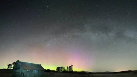 Alan Rankin The image shows the Milky Way and Aurora in the sky above Carrbridge along with the trails of four satellites.