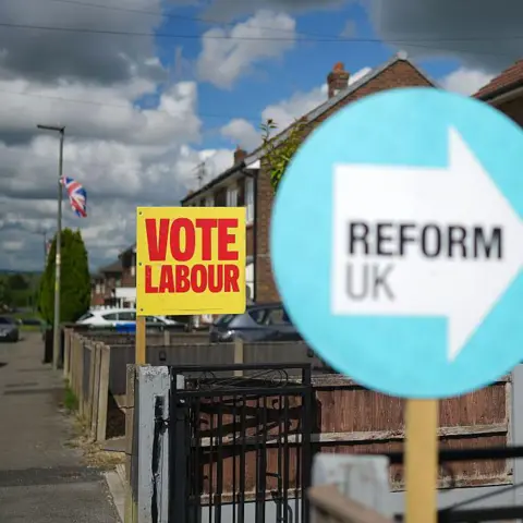 Getty Images Neighbouring homes show their support for Labour and Reform UK with placards ouside their homes on June 10, 2026 in Ashton-in-Makerfield, England