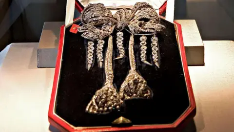 Bloomberg via Getty Images Empress Eugenie's diamond-encrusted brooch, laid out in a display case.