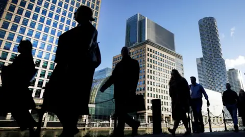 PA Media Office workers and commuters walking through Canary Wharf in London