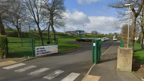 The entrance to Prudhoe Community High School with a panel to one side and a poster saying "attendance matters". 