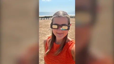 Reporter in eclipse glasses 