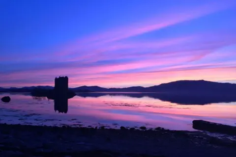 Alfred Cauchi Purple sky reflected in water, also showing the silhouette of a castle.