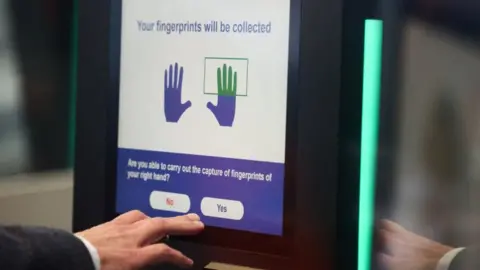 A man operates an automated EES kiosk during a demonstration of the European Union's Entry/Exit System (EES).