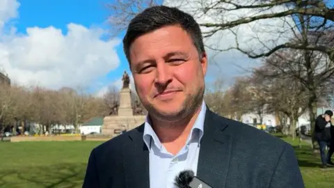 Man wearing suit standing in open park