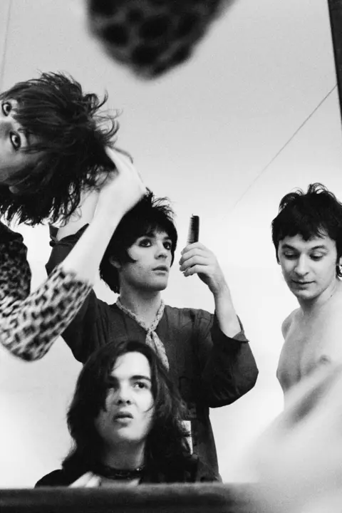 Valerie Phillips Manics band members looking in the mirror combing their hair