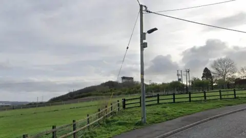 Fields in front of Penshaw monument, which is a grey Classical-style monument.