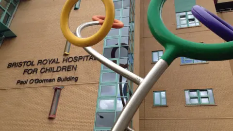 Exterior of Bristol Royal Hospital for Children, a brick building with a colourful sculpture of rings outside