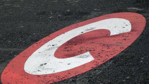 Congestion Charge zone C sign painted on the road which marks the Park Lane boundary in London where the congestion zone starts