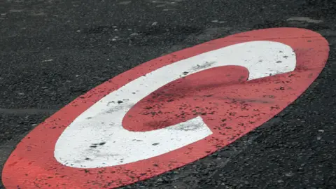 BBC Congestion Charge zone C sign painted on the road which marks the Park Lane boundary in London where the congestion zone starts