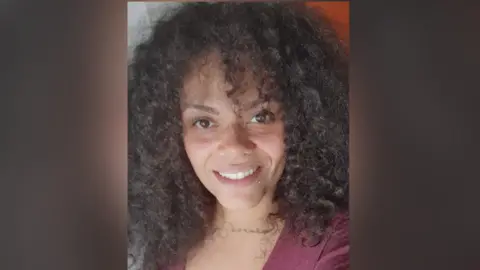 Cherelle Thompson Young woman with curly crown hair smiling in a selfie. She wears a burgandy blouse.