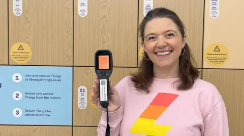 Stuff librarian Heather Mullen wears a pink jacket and holds a thermal camera