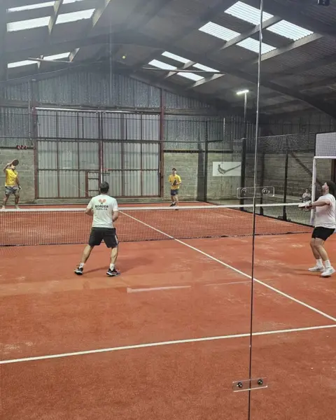 Archie Stewart Another view of the padel court - this time with four players in what clearly looks like a converted barn on a farm