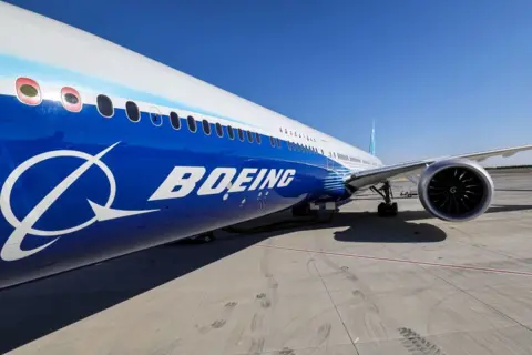 Getty Images A 2023 shot of the fuselage and one of the engines of a Boeing 777-9 jetliner aircraft on the tarmac during the 2023 Dubai Airshow at Dubai World Central - Al-Maktoum International Airport in Dubai. 