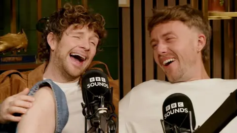 A composite image showing two young men laughing while sitting behind microphones.
