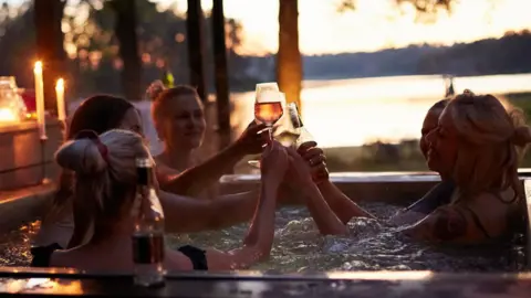 Getty Images A group of women in a hot tub drinking wine