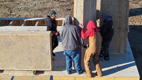 Danny Desjarlais Construction workers move large hempcrete panels.