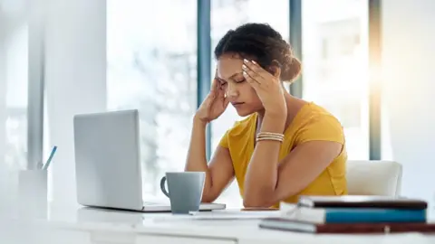 Getty Images Stressed woman at office