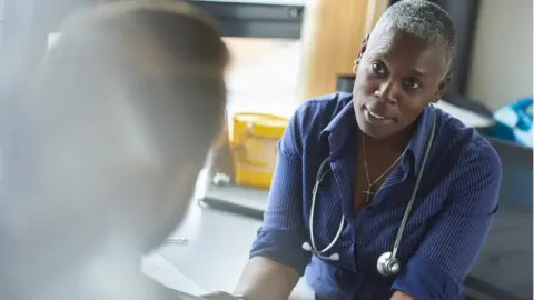 Getty Images A doctor speaking to a patient