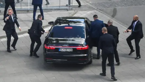 Security guards bundle Slovak PM Robert Fico into a car after shooting attack
